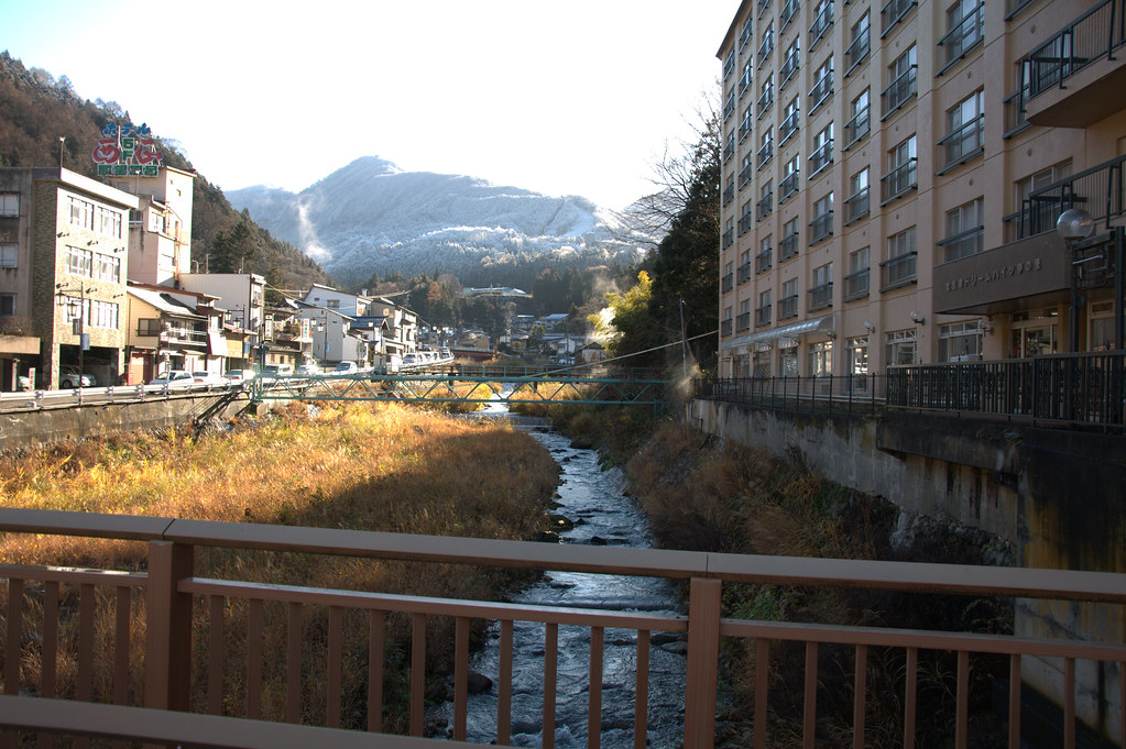 A serene outdoor Japanese onsen with steam rising.
