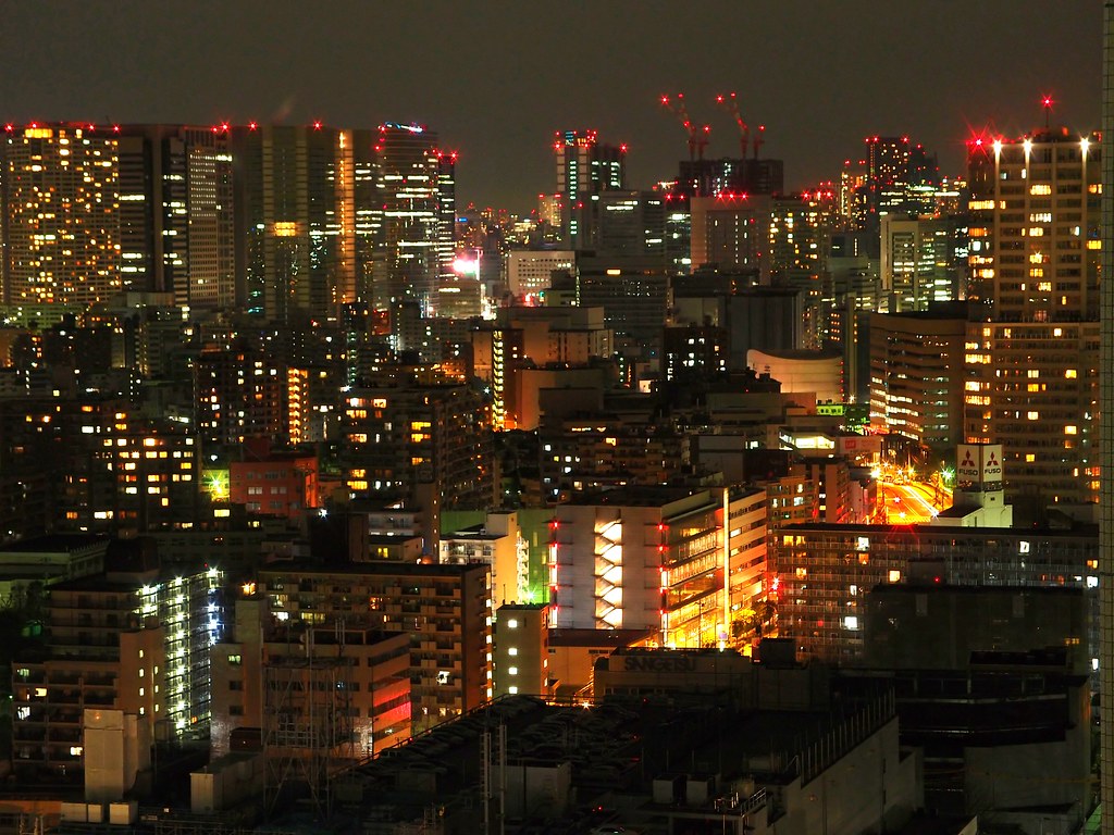 A sweeping nighttime Tokyo skyline seen from a high observation deck.